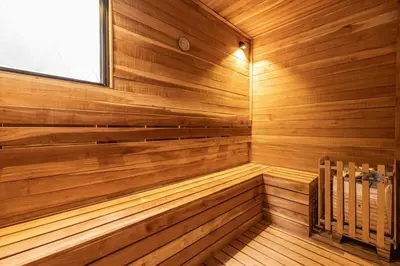 a sauna with wooden paneling and a window at Amazing apartment with Private Luxury Sauna Jacuzzi Steam Room Pool Table in Medellín