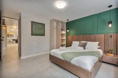 a bedroom with a large bed with a green headboard at Amazing apartment with Private Luxury Sauna Jacuzzi Steam Room Pool Table in Medellín