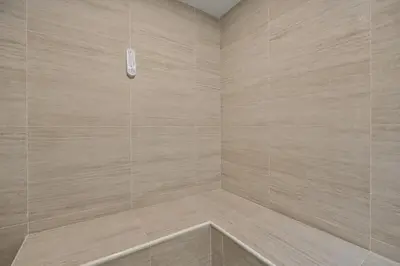 a bathroom with a shower with beige tiles at Amazing apartment with Private Luxury Sauna Jacuzzi Steam Room Pool Table in Medellín