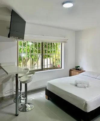 a bedroom with a bed and a desk and a window at Loft Laureles - Excellent location in Medellín