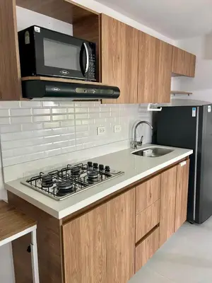 a kitchen with a stove and a microwave at Loft Laureles - Excellent location in Medellín