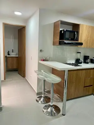 a kitchen with a counter and stools in a room at Loft - Laureles, interno con patio in Medellín