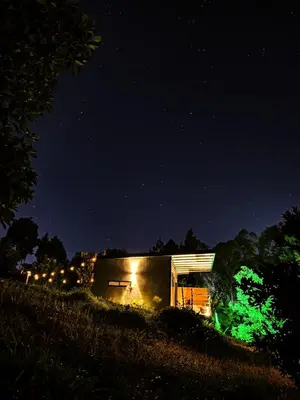 a house with green lights on it at night at Equilibrium glamping in Guarne