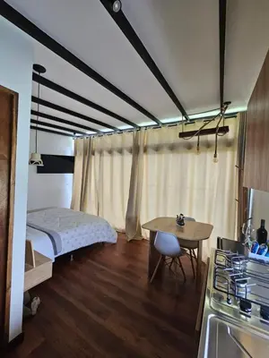 a bedroom with a bed and a table and a kitchen at Equilibrium glamping in Guarne