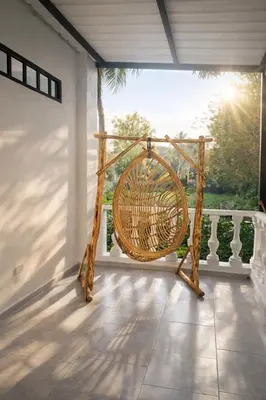 a rattan chair sitting on a porch with a view at KAWARA - Casa IWE in Mariquita