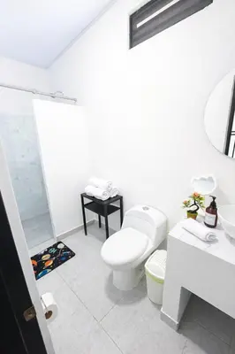a white bathroom with a toilet and a sink at KAWARA - Casa IWE in Mariquita