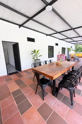 a dining room with a large wooden table and chairs at KAWARA - Casa IWE in Mariquita