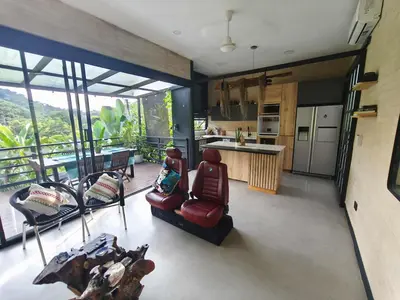 a kitchen with a red chair and a kitchen with windows at Casa Entre Montañas in Titiribí