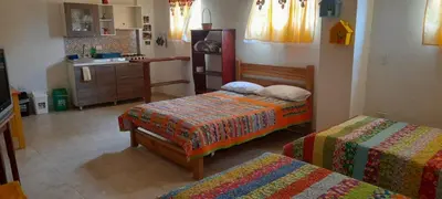 a bedroom with two beds and a kitchen at Hostal LaMula in Jardin