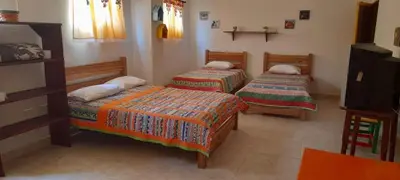 a room with two beds and a tv in it at Hostal LaMula in Jardin