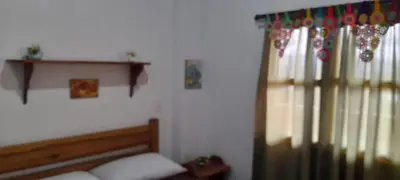 a bedroom with a bed and a window with curtains at Hostal LaMula in Jardin