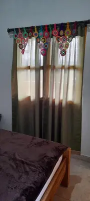 a window with a curtain with beads on it at Hostal LaMula in Jardin