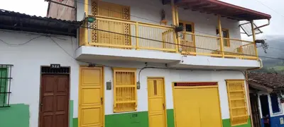 a building with colorful doors and a balcony at Hostal LaMula in Jardin