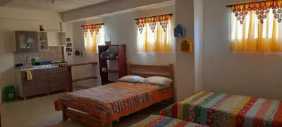 a bedroom with two beds and a sink and a kitchen at Hostal LaMula in Jardin