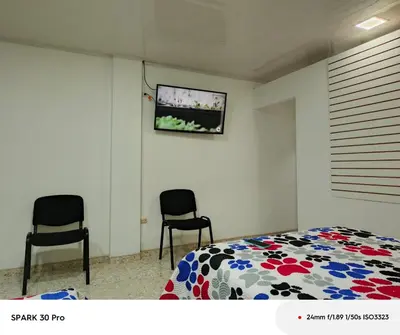 a bedroom with two chairs and a bed and a tv at Apartamento en el centro de Riosucio in Ruiosucio