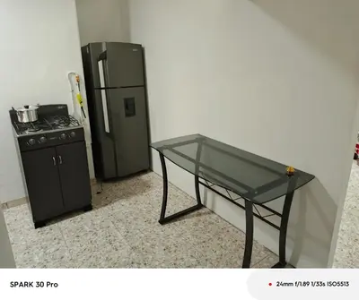 a glass table in front of a refrigerator at Apartamento en el centro de Riosucio in Ruiosucio