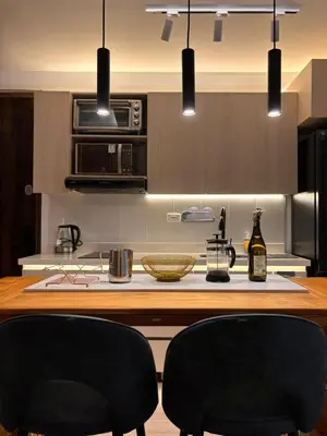 a kitchen with two black chairs at a kitchen island at Modern Loft Puerta de Laureles Medellin in Medellín
