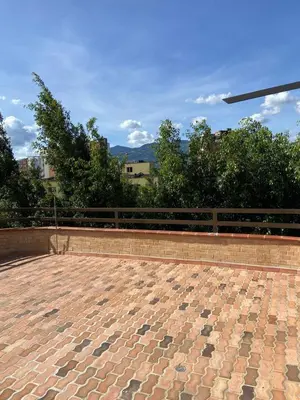 a brick patio with a fence and trees at Modern Loft Puerta de Laureles Medellin in Medellín