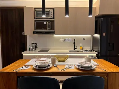 a kitchen with a wooden table with dishes on it at Modern Loft Puerta de Laureles Medellin in Medellín