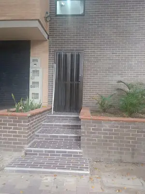 a black door on a brick building with stairs at Modern Loft Puerta de Laureles Medellin in Medellín