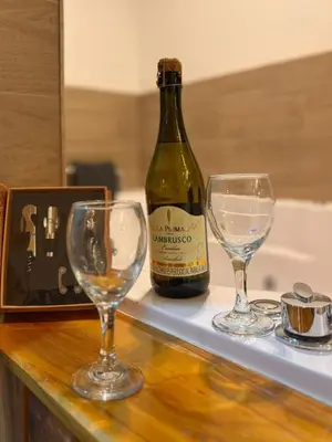 a bottle of wine and two wine glasses on a counter at Modern Loft Puerta de Laureles Medellin in Medellín