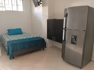 a room with a refrigerator and a bed in it at Apartaestudio Centro Histórico Medellín in Medellín