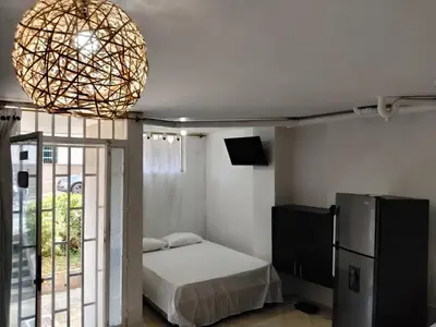 a bedroom with a bed and a large chandelier at Apartaestudio Centro Histórico Medellín in Medellín