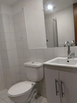 a white bathroom with a toilet and a sink at Apartaestudio Centro Histórico Medellín in Medellín