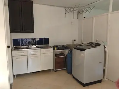 a kitchen with white cabinets and a sink and a dishwasher at Apartaestudio Centro Histórico Medellín in Medellín