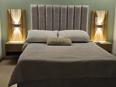 a bedroom with a large bed with two lamps at Loft urbano cerca a cable plaza in Manizales