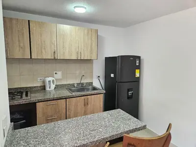 a kitchen with a black refrigerator and a sink at Loft urbano cerca a cable plaza in Manizales