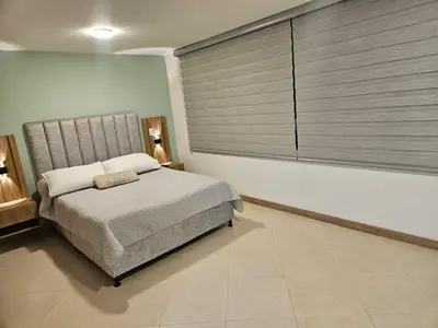 a bedroom with a bed and a large window at Loft urbano cerca a cable plaza in Manizales