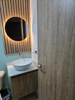a bathroom with a sink and a wooden door at Loft urbano cerca a cable plaza in Manizales