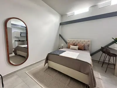 a bedroom with a bed and a large mirror at Espectacular Apartaestudio Batallon Manizales in Manizales
