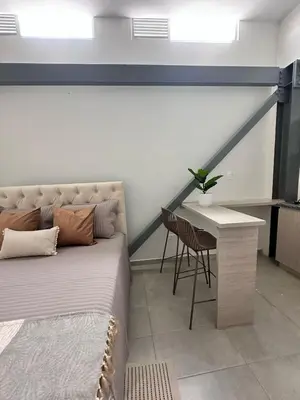 a bedroom with a bed and a table and a chair at Espectacular Apartaestudio Batallon Manizales in Manizales