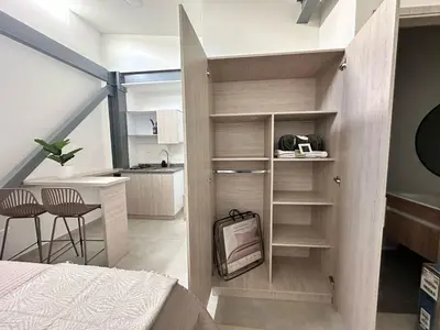 a small room with a bed and a desk and a kitchen at Espectacular Apartaestudio Batallon Manizales in Manizales