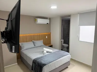 a bedroom with a bed with a tv on the wall at Moderno y acogedor apartamento en sabaneta in Sabaneta