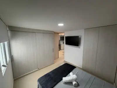 a room with a bed and a tv on the wall at Moderno y acogedor apartamento en sabaneta in Sabaneta
