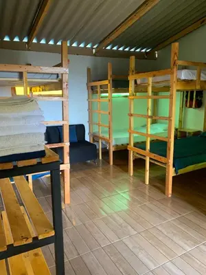 a room with three bunk beds and a table at El Edén in Guarne