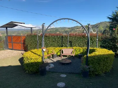 a garden with an arch and a chair and a table at El Edén in Guarne