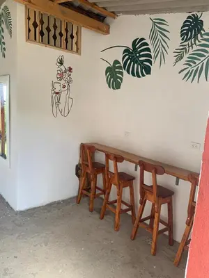 a group of wooden tables and chairs against a wall at El Edén in Guarne