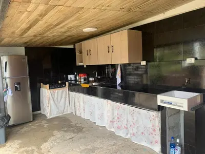 a kitchen with black counter tops and a refrigerator at El Edén in Guarne