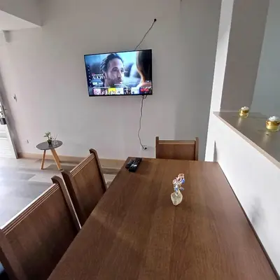 a dining room with a table and a television on the wall at Acogedor Y Amplio Aparta estudio En El Corazón De Manizales in Manizales