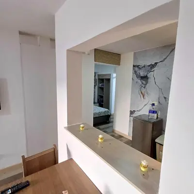 a dining room with a table and a marble wall at Acogedor Y Amplio Aparta estudio En El Corazón De Manizales in Manizales