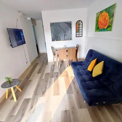 a living room with a blue couch and a table at Acogedor Y Amplio Aparta estudio En El Corazón De Manizales in Manizales
