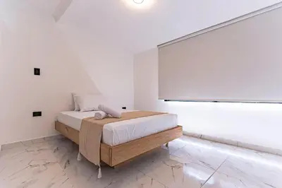 a white bedroom with a bed and a large window at Hotel Loft 72 in Medellín