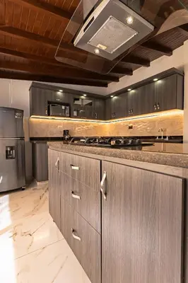 a kitchen with wooden cabinets and a stove top oven at Hotel Loft 72 in Medellín