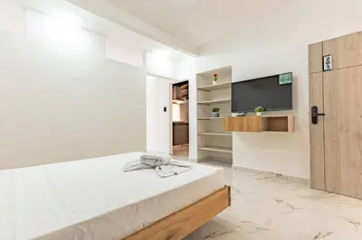 a bedroom with a bed and a flat screen tv at Hotel Loft 72 in Medellín
