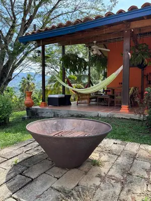 a hammock in front of a house with a patio at Villa en Salgar - Bolombolo in Montenegro