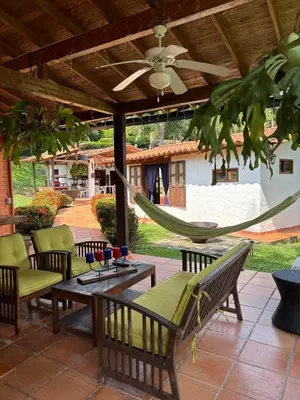 a hammock on a patio with a table and chairs at Villa en Salgar - Bolombolo in Montenegro